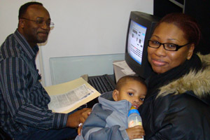 Frank Gant (CEP Volunteer) prepares tax return for Sherry Bowers and her young son.