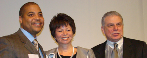 Carlos Nelson poses for a photo opportunity with Valerie Jarrett of The Habitat Company and Andrew Mooney of LISC/Chicago