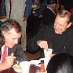 Mayor Daley chats with Fr Michael Pfleger as he eats his peach cobbler dessert